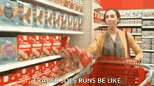 a woman is pushing a shopping cart in a grocery store and says `` trader joe 's runs be like '' .
