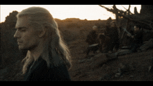 a man with long white hair stands in a field