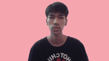 a young man wearing a black shirt that says hoton on it