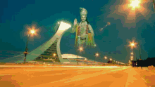 a giant statue of a man is flying over a highway