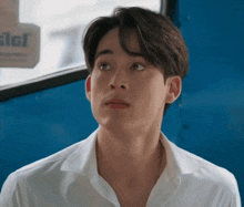 a young man in a white shirt is looking up at something