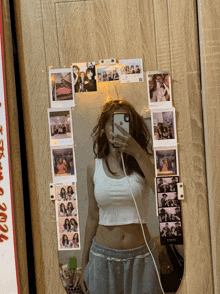 a woman is taking a selfie in front of a mirror that has pictures on it