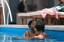 a man and a woman kissing in a pool