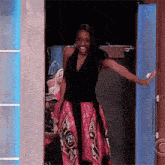 a woman is standing in a doorway with her arms outstretched .