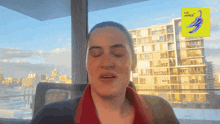 a woman sitting in front of a window with her eyes closed and a yellow sticker that says love plums