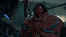 a man in a red cape is talking to another person