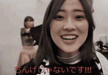 a woman is smiling in front of a sign that has chinese writing on it