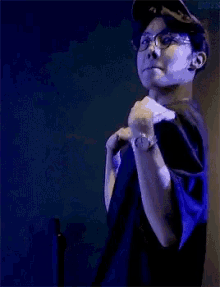 a man wearing a blue shirt and a hat is making a funny face