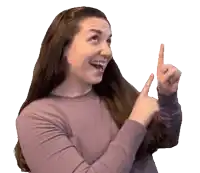 a woman in a purple shirt is pointing up with both hands