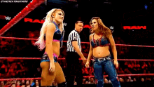 two women are standing in a wrestling ring with a referee and the word raw on the bottom