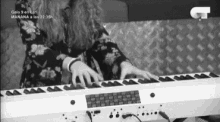 a black and white photo of a woman playing a keyboard