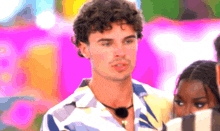 a man with curly hair is standing in front of a woman