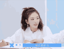 a girl with a ponytail is sitting at a table with a name tag that says ' kkk you ' on it