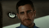 a close up of a man with a beard and a blue shirt