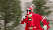 a red power ranger running with a sword