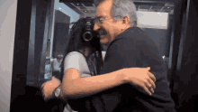 a man is hugging a woman in front of a sign that says ' a ' on it