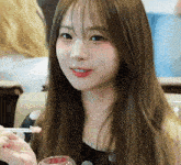 a young woman with long hair is holding a glass and a toothpick in her mouth .