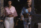two women are standing next to each other in front of a door at night .
