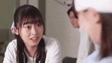 a woman in a white shirt is talking to another woman in a hospital .
