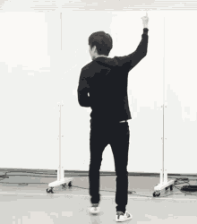 a man standing in front of a mirror with his hand up