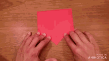a person is holding a piece of red paper .