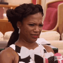 a woman in a black and white dress is making a funny face while sitting in a chair .