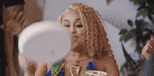 a woman with curly hair is looking at herself in a mirror with the word zeus on the bottom