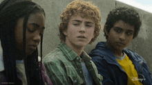 a group of young people sitting next to each other with a disney+ logo on the bottom right