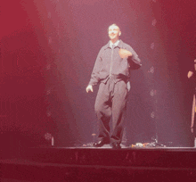 a man in a black jacket is standing on a stage