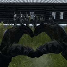 a person making a heart with their hands in front of a group of soldiers