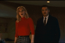a man and a woman standing next to each other in a dark room