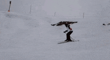 a person is skiing down a snow covered slope while another person is skiing down a snow covered slope .