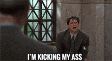 a man in a suit and tie is kneeling down with the words i 'm kicking my ass above him