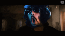 a man wearing headphones and sunglasses is screaming in a dark room with the word off below him
