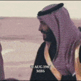 a man in a keffiyeh is standing in a desert on august 31 1985