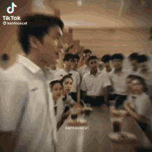 a group of young people are standing around a table in a restaurant .