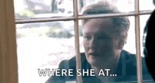 a woman is looking out a window and says `` where she at ... '' .