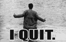 a man is standing in the water with the words `` i quit '' written on the bottom .