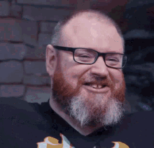 a man with a beard and glasses is smiling with his mouth open