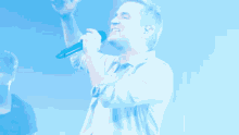 a man singing into a microphone with his arm up in the air