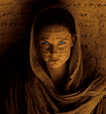a woman with arabic writing on her face has a scarf around her neck