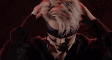 a man wearing a blindfold and ear buds looks at the camera