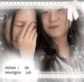 two girls are covering their faces with their hands and smiling for the camera .