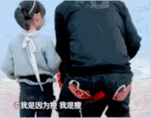 a man and a girl are standing next to each other on a beach