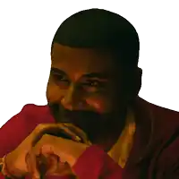 a close up of a man 's face with his hands folded on his chin