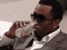 a man in a suit drinking from a glass
