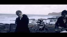 a group of people playing drums and singing in front of a marshall amplifier