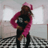 a woman in a pink sweater with the letter s on it
