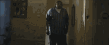 a person is standing in a dark room with a lamp .