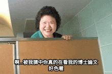 a woman in a green shirt is smiling in a bathroom stall with chinese writing